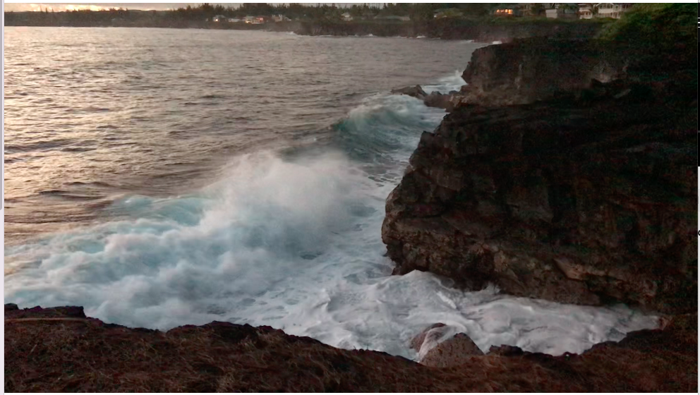 Ocean waves pound against the lava cliffs.