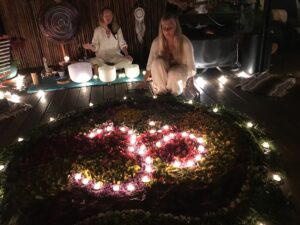 OM mandala made of nature's blossoms and tea candles.  So beautiful, with the two women facilitators